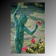 A Bronze statue holds a single flower in a garden on the Amalfi Coast